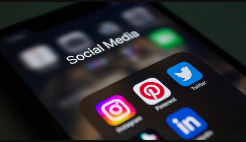 Phone screen showing social media apps including Instagram, Twitter, and Pinterest, representing how to go viral on social media