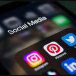 Phone screen showing social media apps including Instagram, Twitter, and Pinterest, representing how to go viral on social media