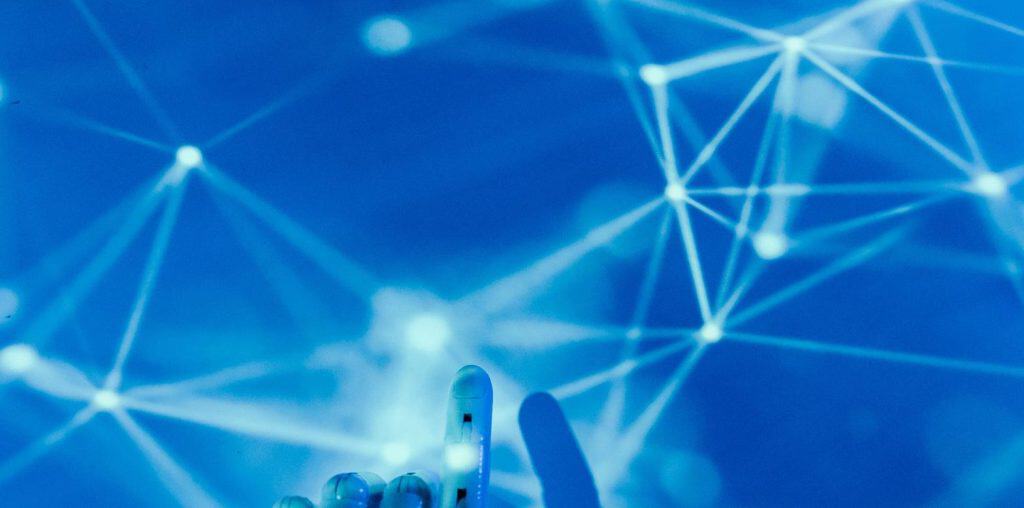 Futuristic digital network with interconnected nodes and a hand touching the screen.