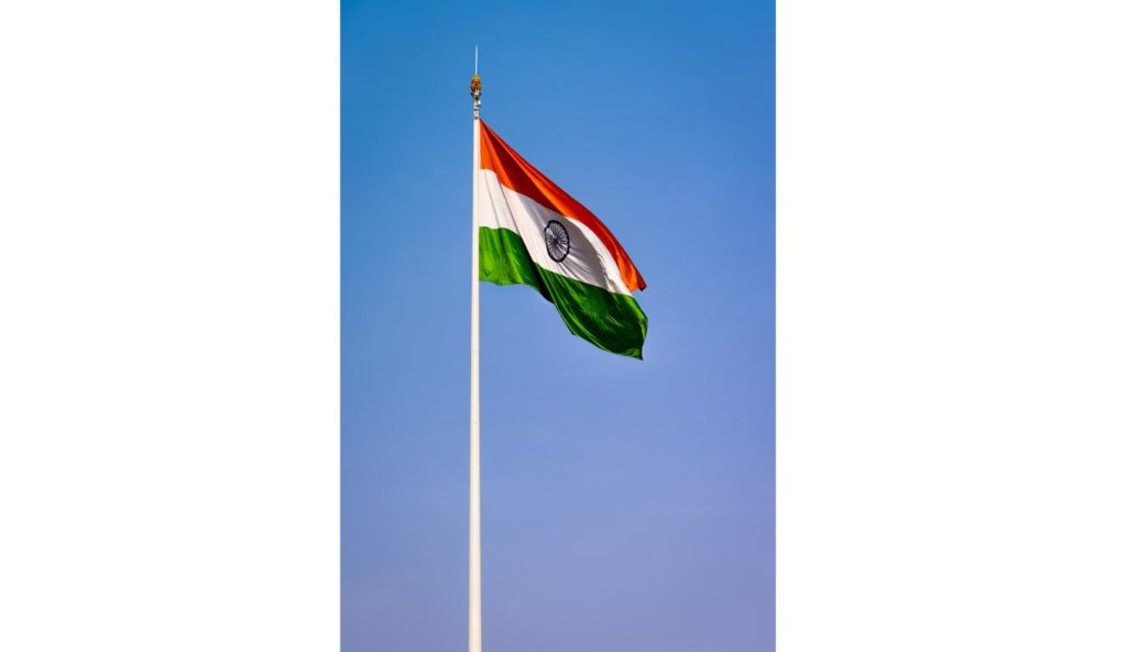 Indian national flag flying against a clear blue sky, symbolizing the political standoff over the protests