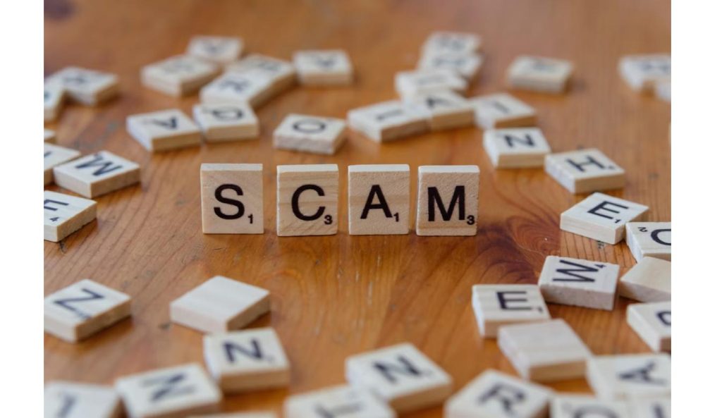 Word "SCAM" spelled in scrabble tiles, representing digital privacy risks from phishing