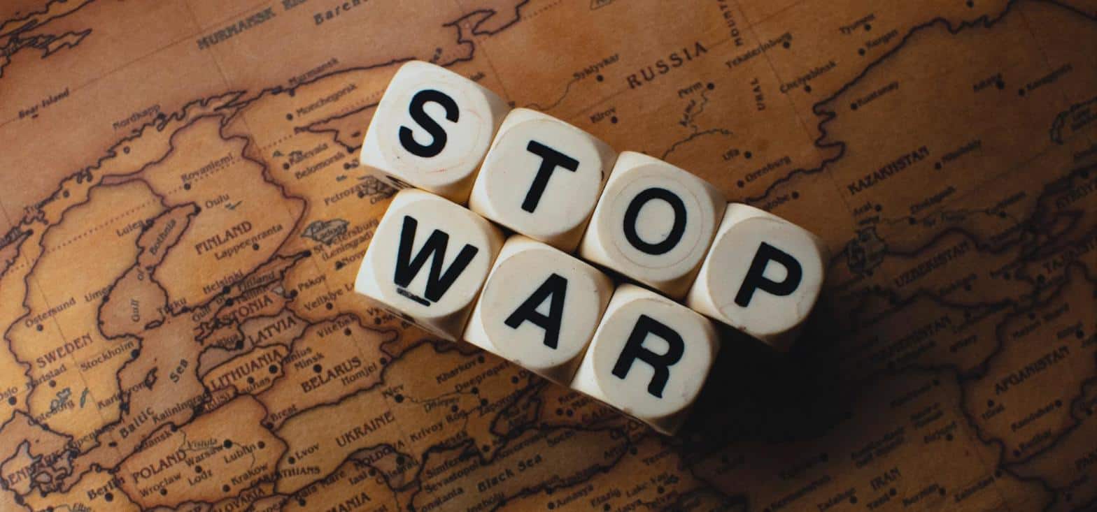 Dice reading stop war on a world map, symbolizing today's global flashpoints