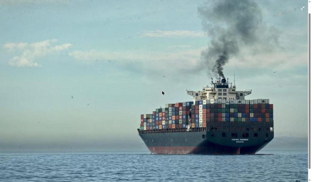Cargo ship emitting dark smoke at sea, representing the fire aboard LNG tankers after the Damietta port drone attack